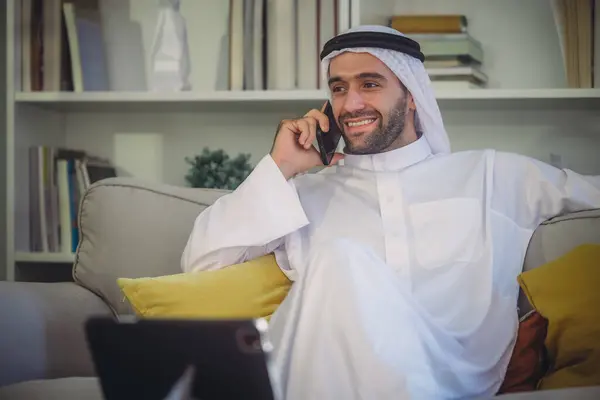 Sheikh, CEO in arb dress, supervising business, distant meetings, and communication via video call with the team with a smile gesture. Overseeing operations as a leader, showcasing responsibilities.