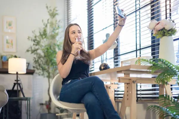 Neşeli Bir Kadın Modern Ofis Ortamında Akıllı Telefonuyla Selfie Çeker — Stok fotoğraf