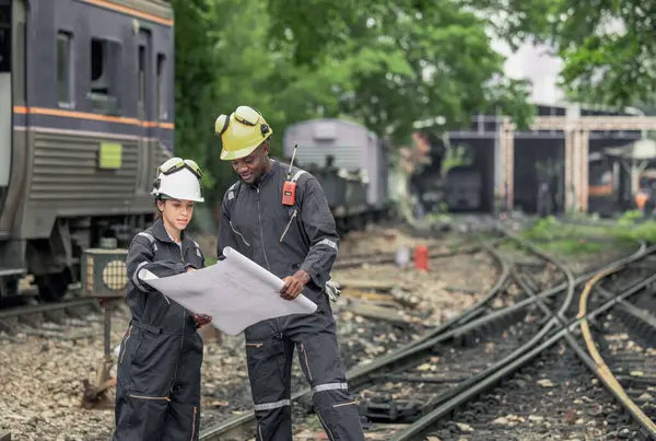 机车工程师合作和参考蓝图 以指导维修任务 解决铁路基础设施和网络内部的问题 确保列车运营的可靠性和安全性 — 图库照片