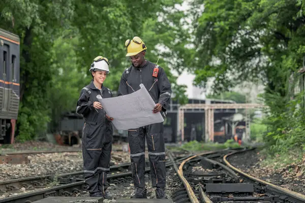 机车工程师合作和参考蓝图 以指导维修任务 解决铁路基础设施和网络内部的问题 确保列车运营的可靠性和安全性 — 图库照片