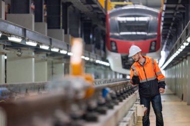 Demiryolu bakım mühendisi altyapının durumunu değerlendiriyor. Karbondioksit ayak izini azaltan, enerji verimliliğini arttıran, sürdürülebilir uygulamalara odaklanan demiryolu sistemine güncellemeler planlamak ve uygulamak