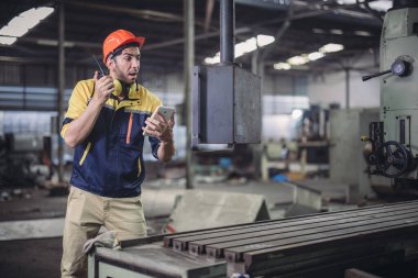 Teknisyen sorun çözüyor, ayarları değiştiriyor, işlemleri etkinleştiriyor ve fabrika tesisinde makineler çalıştırıyor. Gerçek zamanlı veri kullanarak makinenin performansını düzenler.