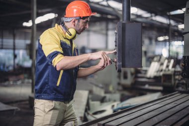 Teknisyen sorun çözüyor, ayarları değiştiriyor, işlemleri etkinleştiriyor ve fabrika tesisinde makineler çalıştırıyor. Gerçek zamanlı veri kullanarak makinenin performansını düzenler.