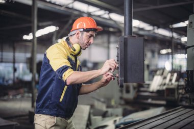 Teknisyen sorun çözüyor, ayarları değiştiriyor, işlemleri etkinleştiriyor ve fabrika tesisinde makineler çalıştırıyor. Gerçek zamanlı veri kullanarak makinenin performansını düzenler.