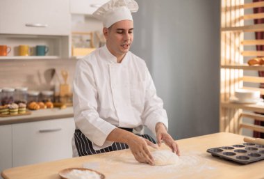 Profesyonel usta aşçı, ticari bir mutfakta ekmek yapmanın ilk aşamalarında un yüzeyinde yoğurur. Yemek için gösteri becerileri, teknik, hassasiyet, tutku ve sanatsallık.