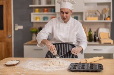 Profesyonel usta aşçı, ticari bir mutfakta ekmek yapmanın ilk aşamalarında un yüzeyinde yoğurur. Yemek için gösteri becerileri, teknik, hassasiyet, tutku ve sanatsallık.