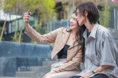 Asyalı aşıklar dışarıda eğlenceli etkileşimlere girerler. Gözleri sevgi dolu bakışlarla buluşur, sevgi ve şefkat saçar. Gülen ve samimi anlar paylaşan İçtenlik ve neşe dolu.