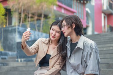 Asyalı aşıklar dışarıda eğlenceli etkileşimlere girerler. Gözleri sevgi dolu bakışlarla buluşur, sevgi ve şefkat saçar. Gülen ve samimi anlar paylaşan İçtenlik ve neşe dolu.