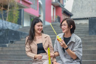 Asyalı aşıklar dışarıda eğlenceli etkileşimlere girerler. Gözleri sevgi dolu bakışlarla buluşur, sevgi ve şefkat saçar. Gülen ve samimi anlar paylaşan İçtenlik ve neşe dolu.