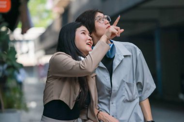 Asyalı aşıklar dışarıda eğlenceli etkileşimlere girerler. Gözleri sevgi dolu bakışlarla buluşur, sevgi ve şefkat saçar. Gülen ve samimi anlar paylaşan İçtenlik ve neşe dolu.