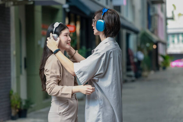 Asian lovers engage in playful interactions outdoors. Their eyes meet with affectionate gaze, radiating love and tenderness. Laughing and sharing intimate moments filled with warmth and playfulness.