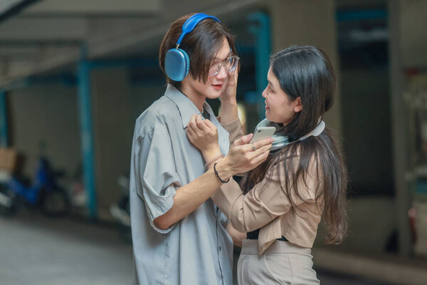 Asian lovers engage in playful interactions outdoors. Their eyes meet with affectionate gaze, radiating love and tenderness. Laughing and sharing intimate moments filled with warmth and playfulness.