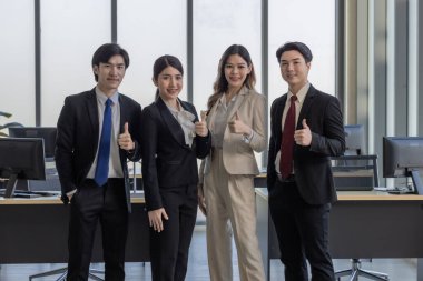 Modern ofis ortamında takım çalışmasını ve başarıyı sembolize eden dört iş adamından oluşan bir grup..