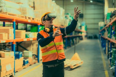 Modern depo ortamında dijital arayüzle etkileşime geçmek için sanal gerçeklik gözlüğü takan bir depo çalışanı. Gelişmiş teknolojinin lojistik ve envanter yönetimine entegrasyonu.