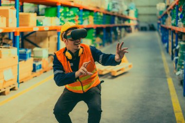 Modern depo ortamında dijital arayüzle etkileşime geçmek için sanal gerçeklik gözlüğü takan bir depo çalışanı. Gelişmiş teknolojinin lojistik ve envanter yönetimine entegrasyonu.