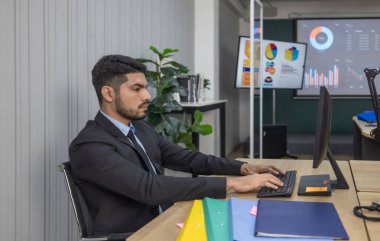 Takım elbiseli profesyonel iş adamı, modern bir ofiste dizüstü bilgisayara çok önem verir. Kurumsal iş ortamları ve iş karar verme senaryoları için konsantrasyon ve ciddiyet.