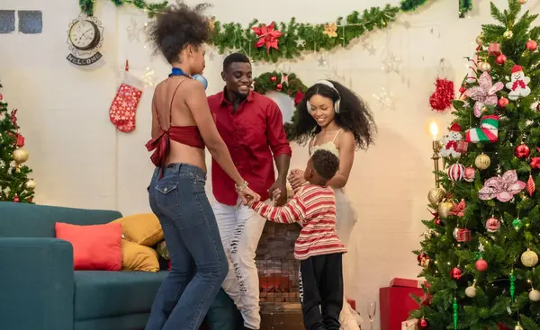 Siyah bir ailenin dans edişinin ve Noel partisinde hediye alışverişinin neşeli ve iç açıcı bir sahnesi, şenlikli dekorasyonlarla çevrili. Aile toplantısının keyifli anları.