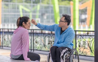 Bir çift, bir açık hava aktivitesi sırasında sırayla birbirlerinin terlerini silerler. Bağlarını ve karşılıklı sevgilerini vurgulayan şefkatli ve destekleyici bir etkileşim paylaşırlar..