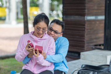 Tekerlekli sandalyedeki neşeli bir adam, partnerine nazik bir hediyeyle sürpriz yapar. Açık havada şefkatli bir anı kucaklayıp paylaşırlar. Kadın sıcak bir şekilde gülümsüyor, aşkın özel jestini sevgiyle anarak..