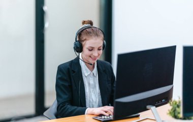 İş kadını, rapor üzerinde çalışırken masasında oturuyor. Modern ofis ortamı, bilgisayar ve düzenli çalışma alanı ile birlikte, verimliliği, verimliliği ve pozitif çalışma ortamını yansıtır..