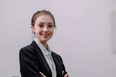 İş kadını, rapor üzerinde çalışırken masasında oturuyor. Modern ofis ortamı, bilgisayar ve düzenli çalışma alanı ile birlikte, verimliliği, verimliliği ve pozitif çalışma ortamını yansıtır..