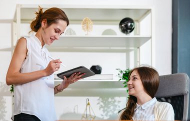 Diğer takım üyeleri toplantıya dikkatle katılırken, profesyonel iş adamları modern ofis ortamında dizüstü bilgisayarla bir tartışmaya giriştiler..