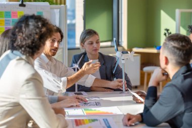 Çeşitli bir girişim ekibi güçlü, hafif, taşınabilir rüzgar türbini prototipi üzerinde, potansiyel kullanıcı talebiyle hizalanan ve yatırımcı finansmanı sağlamak için yenilenebilir enerji gereksinimleriyle işbirliği yapar..