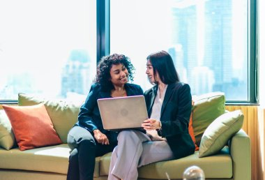 Modern bir ofiste dizüstü bilgisayar üzerinde çalışırken iki iş adamı ortak bir tartışmaya girişirler. Odaklanmış ve hevesli görünüyorlar, üretken ve dostane bir çalışma ortamı yansıtıyorlar..