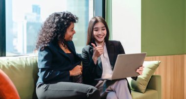 Modern bir ofiste dizüstü bilgisayar üzerinde çalışırken iki iş adamı ortak bir tartışmaya girişirler. Odaklanmış ve hevesli görünüyorlar, üretken ve dostane bir çalışma ortamı yansıtıyorlar..