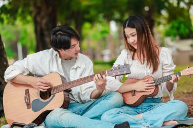 Asyalı bir çift göl kenarında barışçıl bir pikniğin keyfini çıkarırken, akustik gitar çalan bir adam da birbirlerine sıcak bir şekilde bağlanıyorlar. Doğal ortamdaki romantik ve müzikal bir an..