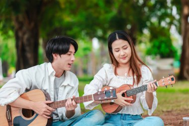 Asyalı bir çift göl kenarında barışçıl bir pikniğin keyfini çıkarırken, akustik gitar çalan bir adam da birbirlerine sıcak bir şekilde bağlanıyorlar. Doğal ortamdaki romantik ve müzikal bir an..