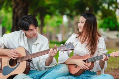 Asyalı bir çift göl kenarında barışçıl bir pikniğin keyfini çıkarırken, akustik gitar çalan bir adam da birbirlerine sıcak bir şekilde bağlanıyorlar. Doğal ortamdaki romantik ve müzikal bir an..