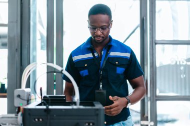 Mühendis, ileri üretim ve prototip teknolojisi sergileyen bir atölyede yeni basılmış üç boyutlu bileşenleri inceliyor. Yenilikleri yansıtan, hassas mühendislik, endüstriyel tasarım süreçleri