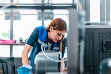 Mühendis, ileri üretim ve prototip teknolojisi sergileyen bir atölyede yeni basılmış üç boyutlu bileşenleri inceliyor. Yenilikleri yansıtan, hassas mühendislik, endüstriyel tasarım süreçleri