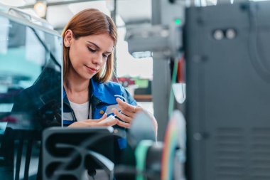 Mühendis, ileri üretim ve prototip teknolojisi sergileyen bir atölyede yeni basılmış üç boyutlu bileşenleri inceliyor. Yenilikleri yansıtan, hassas mühendislik, endüstriyel tasarım süreçleri