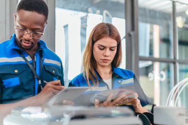 3D yazıcının yanında dikilirken mühendisler renk örnekleme kılavuzunu gözden geçirir, geri dönüşümlü 3D yazdırılmış ürünler için renk seçerler. Üretim süreçlerinde yaratıcılık, sürdürülebilirlik ve kesinliğin vurgulanması