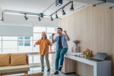 Takım üyeleri modern ofis ortamında başarılı bir projeyi coşkuyla kutluyorlar. Takım çalışmasını, motivasyonu ve başlangıç ortamında hedeflere ulaşmanın sevincini yakaladığınız an.