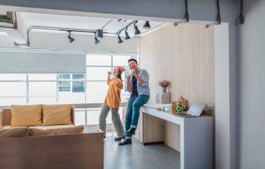 Takım üyeleri modern ofis ortamında başarılı bir projeyi coşkuyla kutluyorlar. Takım çalışmasını, motivasyonu ve başlangıç ortamında hedeflere ulaşmanın sevincini yakaladığınız an.