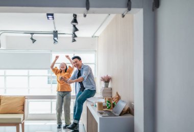 Takım üyeleri modern ofis ortamında başarılı bir projeyi coşkuyla kutluyorlar. Takım çalışmasını, motivasyonu ve başlangıç ortamında hedeflere ulaşmanın sevincini yakaladığınız an.