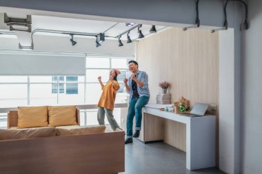 Takım üyeleri modern ofis ortamında başarılı bir projeyi coşkuyla kutluyorlar. Takım çalışmasını, motivasyonu ve başlangıç ortamında hedeflere ulaşmanın sevincini yakaladığınız an.