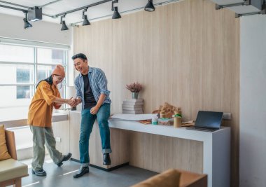 Takım üyeleri modern ofis ortamında başarılı bir projeyi coşkuyla kutluyorlar. Takım çalışmasını, motivasyonu ve başlangıç ortamında hedeflere ulaşmanın sevincini yakaladığınız an.