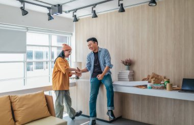 Takım üyeleri modern ofis ortamında başarılı bir projeyi coşkuyla kutluyorlar. Takım çalışmasını, motivasyonu ve başlangıç ortamında hedeflere ulaşmanın sevincini yakaladığınız an.