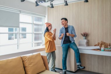 Takım üyeleri modern ofis ortamında başarılı bir projeyi coşkuyla kutluyorlar. Takım çalışmasını, motivasyonu ve başlangıç ortamında hedeflere ulaşmanın sevincini yakaladığınız an.