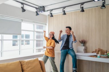 Takım üyeleri modern ofis ortamında başarılı bir projeyi coşkuyla kutluyorlar. Takım çalışmasını, motivasyonu ve başlangıç ortamında hedeflere ulaşmanın sevincini yakaladığınız an.