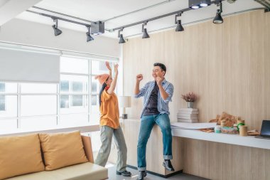 Takım üyeleri modern ofis ortamında başarılı bir projeyi coşkuyla kutluyorlar. Takım çalışmasını, motivasyonu ve başlangıç ortamında hedeflere ulaşmanın sevincini yakaladığınız an.