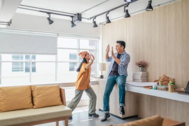 Takım üyeleri modern ofis ortamında başarılı bir projeyi coşkuyla kutluyorlar. Takım çalışmasını, motivasyonu ve başlangıç ortamında hedeflere ulaşmanın sevincini yakaladığınız an.