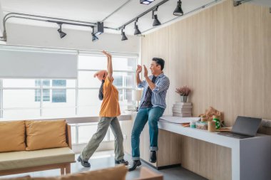 Takım üyeleri modern ofis ortamında başarılı bir projeyi coşkuyla kutluyorlar. Takım çalışmasını, motivasyonu ve başlangıç ortamında hedeflere ulaşmanın sevincini yakaladığınız an.