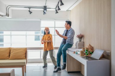 Takım üyeleri modern ofis ortamında başarılı bir projeyi coşkuyla kutluyorlar. Takım çalışmasını, motivasyonu ve başlangıç ortamında hedeflere ulaşmanın sevincini yakaladığınız an.