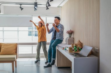 Takım üyeleri modern ofis ortamında başarılı bir projeyi coşkuyla kutluyorlar. Takım çalışmasını, motivasyonu ve başlangıç ortamında hedeflere ulaşmanın sevincini yakaladığınız an.