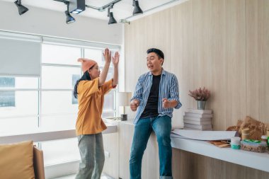 Takım üyeleri modern ofis ortamında başarılı bir projeyi coşkuyla kutluyorlar. Takım çalışmasını, motivasyonu ve başlangıç ortamında hedeflere ulaşmanın sevincini yakaladığınız an.